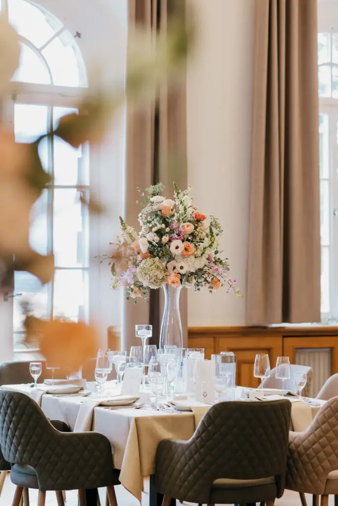 Festlich gedeckter Hochzeitstisch mit Blumengesteck im Jagdschloss